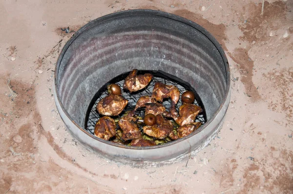 Roasted dinner in pit with metal vessel dug into ground in Wadi Rum Jorda