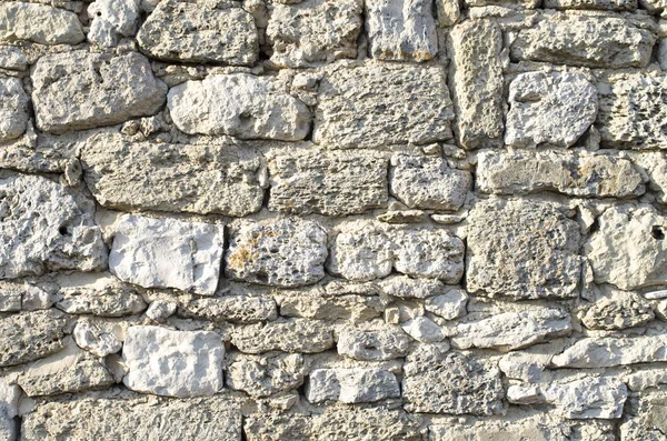 Old relief ecru limestone wall closeu