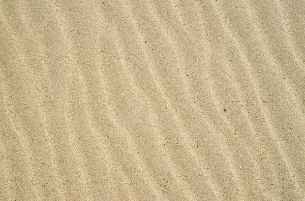 Sable jaune avec vagues sur la plage gros plan — Photo