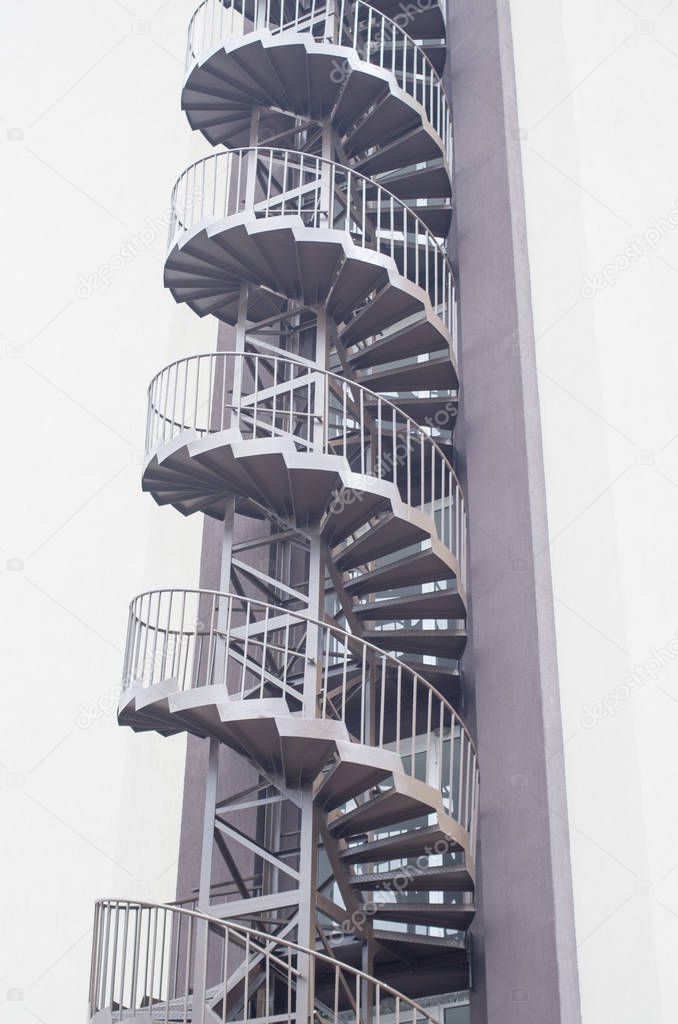 Spiral fire escape stairs outside building facade in hotel