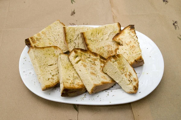 Gebratene Scheiben hausgemachtes Brot mit Olivenöl im Teller — Stockfoto