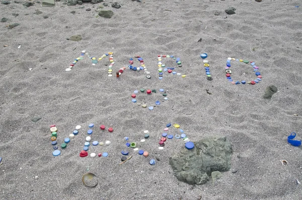 Inscriptie op het strand van plastic caps "Mario Love Vera" — Stockfoto