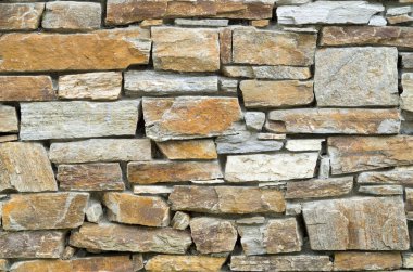 Güneşli bölgede eski renkli taş duvar kapanıyor.