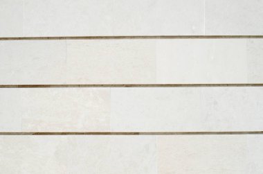 Duvarda yeni beyaz taş levhalar var.