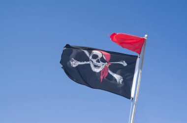 Gökyüzünde kırmızı bayrak ve sırıtan kafatası ile blackjack