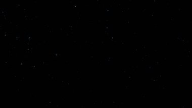 Açık mavi toz parçacığı siyah arkaplanda yüzer.