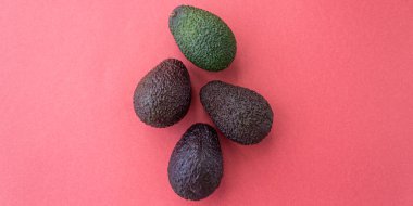 Kırmızı arka planda farklı olgunlukta Avokado bayrağı. Düz yatış stili. Kapatın. Metin için yer