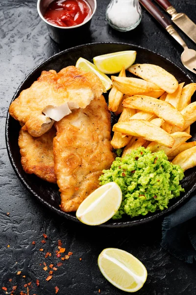 British Traditional Fish and chips with mashed peas and sauce.