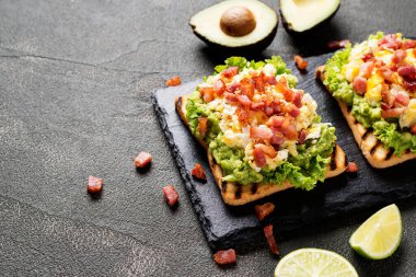 Avokado, omlet ve pastırmalı ev yapımı tost sandviçi..