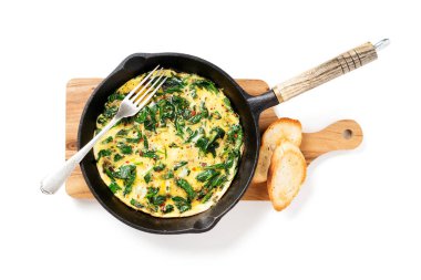 Bebek ıspanaklı omlet, dökme demir tavada, sağlıklı kahvaltı. beyaz arkaplanda izole.