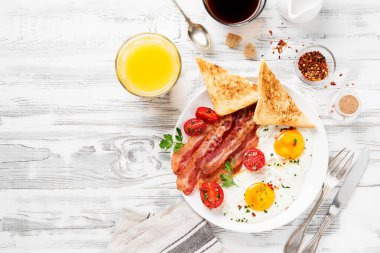 İki kızarmış yumurta, domates salatası, pastırma, tost, portakal suyu ve kahve ile Amerikan kahvaltısı..