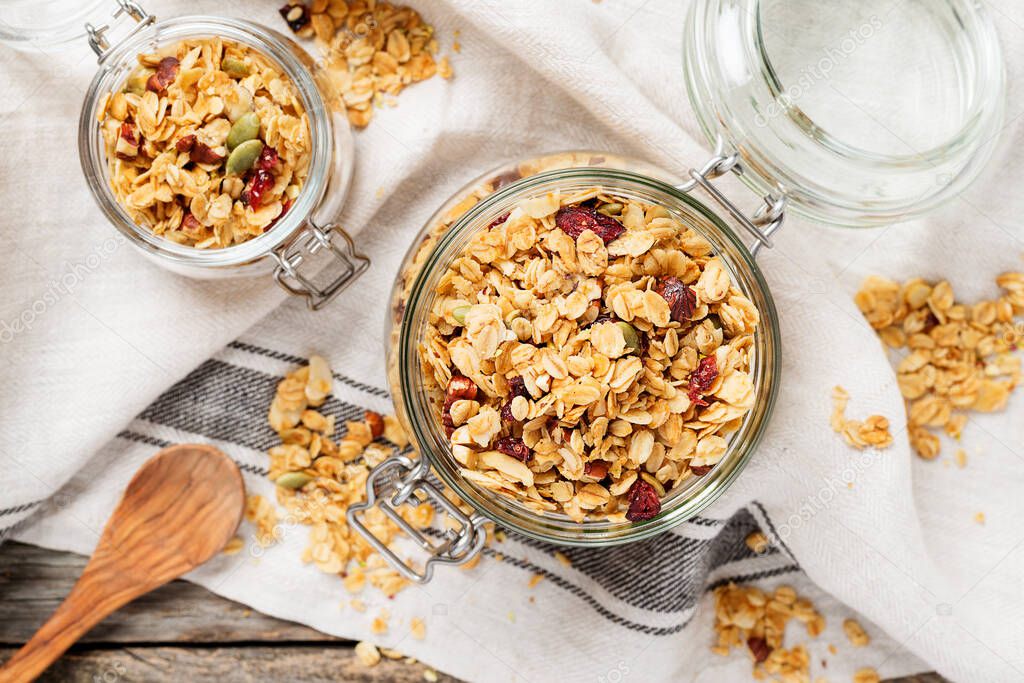 Homemade granola with nuts and seeds in glass jar for healthy breakfast