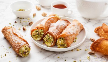 Ricotta peyniri ve şam fıstığı ile doldurulmuş ev yapımı tatlı cannoli. Sicilya tatlısı. İtalyan pastası..
