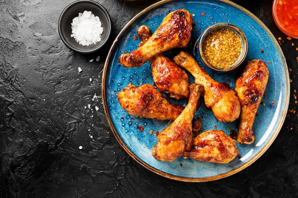 Roasted spicy chicken legs with mustard and chili sauce.