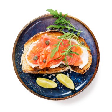 Sağlıklı kahvaltı için füme ve tuzlu somonlu sandviç. Beyaz arka planda izole edilmiş.