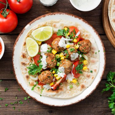 Kızarmış köfteli tortilla, mısır ve taze salata. en üstteki görünüm