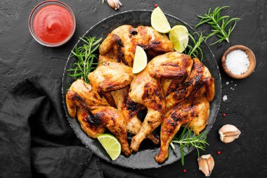 Aile yemeği için siyah arka planda serpiştirilmiş ızgara tavuk.