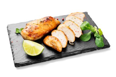 Izgara tavuk göğsü. Beyaz arka planda limonlu dilimlenmiş tavuk filetosu.