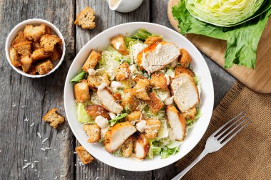 Kızarmış tavuk filetosu ve parmesan peynirli klasik sezar salatası. Üst görünüm