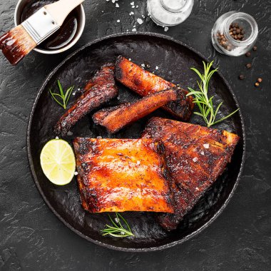 Izgara ve füme domuz pirzolası, barbekü sosu ve biberiye..