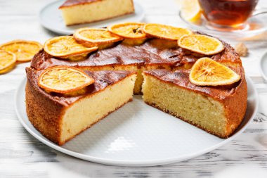 Kurutulmuş portakal dilimleriyle süslenmiş dilimlenmiş Semolina keki..