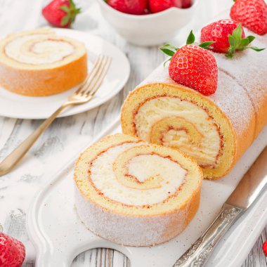 Krem peynirle doldurulmuş lezzetli rulo pasta, taze çilekle süslenmiş.