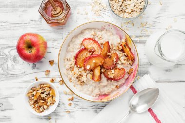 Karamelli yulaf lapası ve beyaz ahşap arka planda fındık..