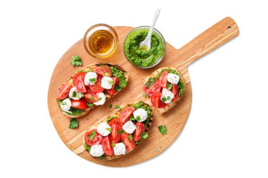 Kirazlı domates, mozzarella peyniri ve ahşap tahtada pesto sosu. Geleneksel İtalyan aperatifi veya aperatifi, antipasto. beyaz arkaplanda izole