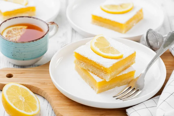 Lemon bar dessert with powdered sugar and lemon slices