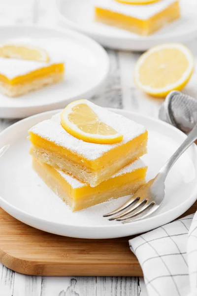 Lemon bar dessert with powdered sugar and lemon slices