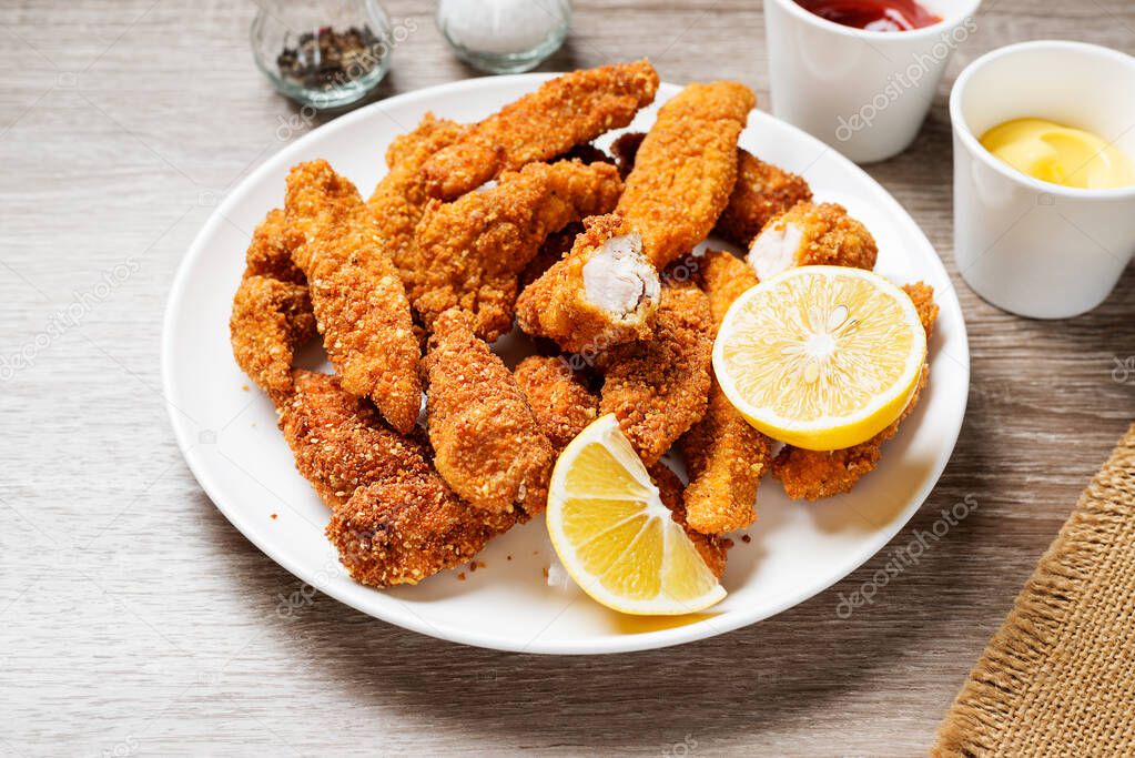 Delicious crispy fried breaded chicken breast strips .