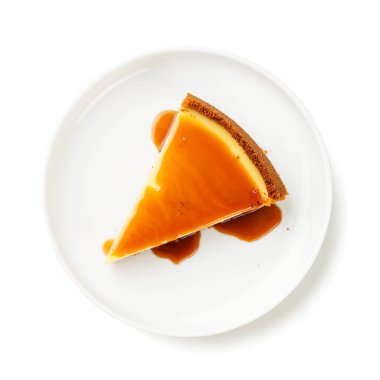 Beyaz arka planda izole edilmiş beyaz tabakta karamel soslu cheesecake dilimi