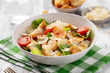 Beyaz ahşap arka planda karidesli klasik İtalyan Sezar Salatası.