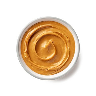 Beyaz arka planda izole edilmiş kremalı fıstık ezmeli seramik kase.