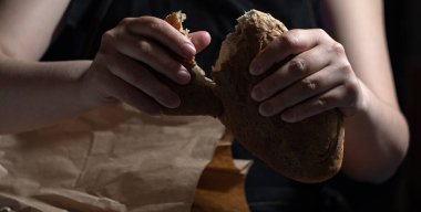 Kese kağıdından çıkarılan taze ekmeğin iştahı açıldı. Koyu arkaplan.