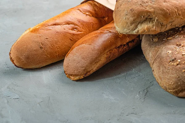 Fresh homemade crisp bread and baguettes close-up. Concept for banners, top view on a gray background.