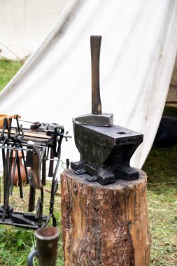 Kütüğün üzerinde demirci aletleri var: çekiç ve örs. El işi kavramı, zanaat. Boşluğu kopyala.