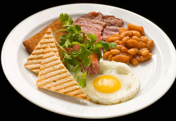 Английский завтрак: яичница, бекон, бобы и тосты на тарелке . — стоковое фото