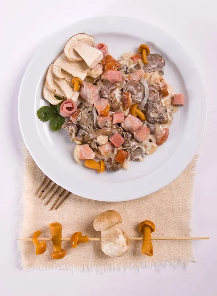 Грибной салат с белыми грибами, медовый агарик, бекон, подается с сыром пармезан на белой тарелке. close up — стоковое фото