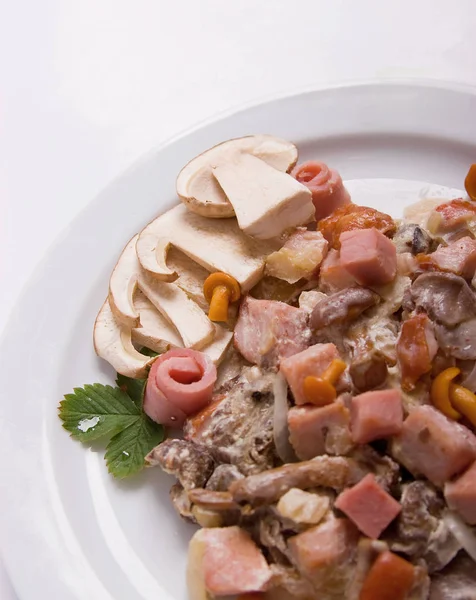 Грибной салат с белыми грибами, медовый агарик, бекон, подается с сыром пармезан на белой тарелке. close up — стоковое фото