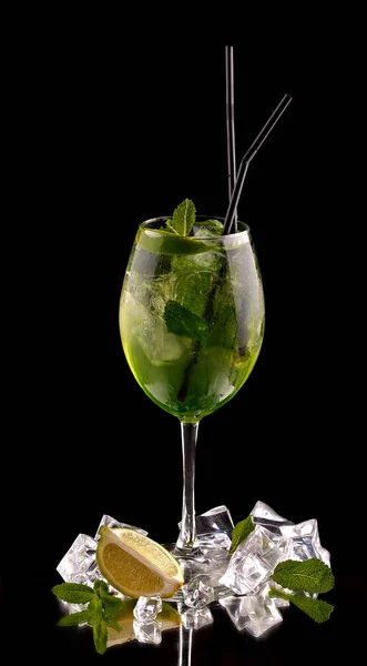 Cóctel de alcohol sobre un fondo negro con frutas frescas de verano y cubitos de hielo —  Fotos de Stock