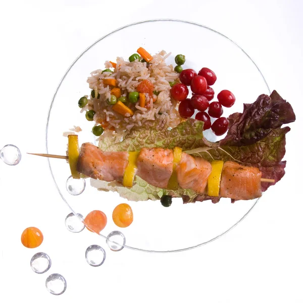 Kuřecí kebab s rýží a zeleninou na bílém podkladu na průhledné desce se skleněnými kameny — Stock fotografie