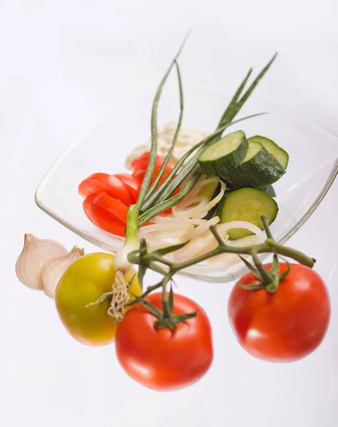 Insalata con panna acida, cipolle, pomodori e cetrioli su un piatto trasparente — Foto Stock
