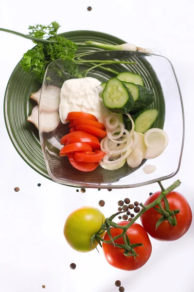 Ensalada con crema agria, cebollas, tomates y pepinos en un plato transparente — Foto de Stock