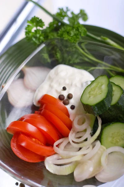 Ensalada con crema agria, cebollas, tomates y pepinos en un plato transparente — Foto de Stock