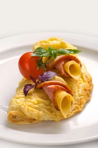 Tortilla de huevo con jamón y queso, decorado con tomates cherry y albahaca, primer plano — Foto de Stock