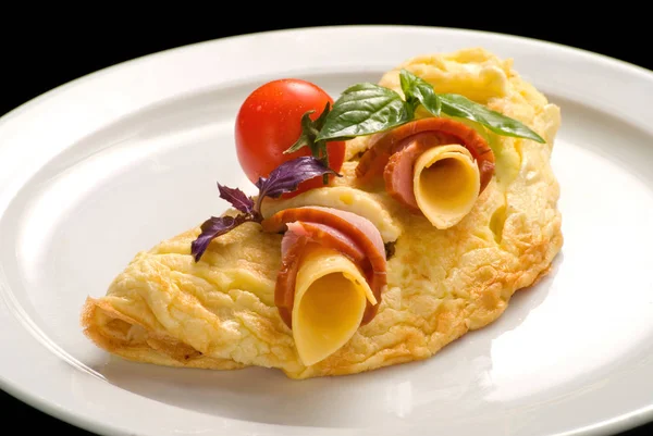 Tortilla de huevo con jamón y queso, decorado con tomates cherry y albahaca, primer plano — Foto de Stock
