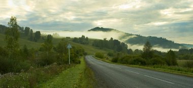 Yol, tepeler ve sabah sisi.