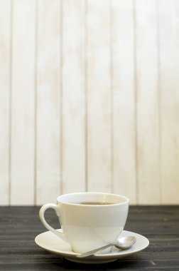 Ahşap arka plan üzerinde kaşık ile çay Fincan