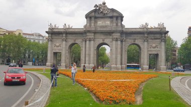 Gün batımında Puerta de Alcala'da fotoğraf çeken turistler